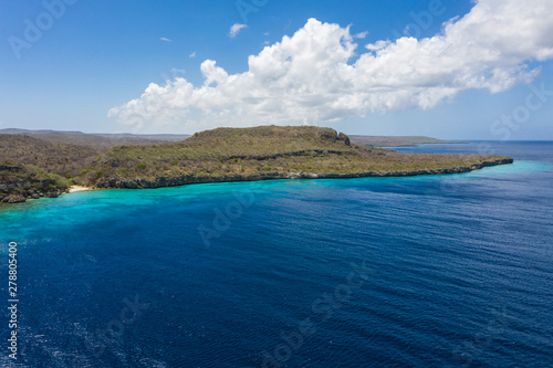 Aerial view of coast of Curaçao in the Caribbean Sea with turquoise water, white sandy beach and beautiful coral reef at Playa Manzalina 