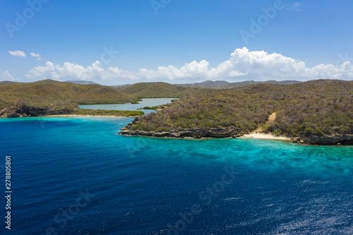 Aerial view of coast of Curaçao in the Caribbean Sea with turquoise water, white sandy beach and beautiful coral reef at Playa Manzalina 