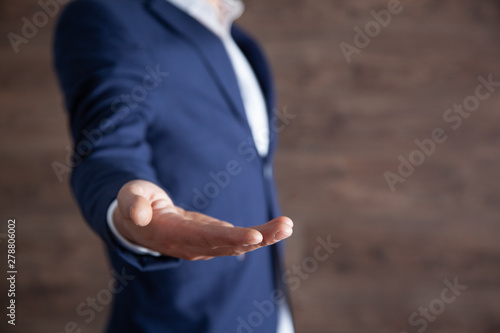 young man empty palm on dark background