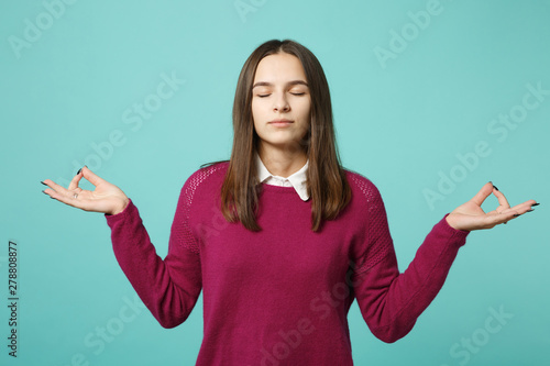 Young brunette woman girl in casual clothes posing isolated on blue turquoise wall background studio portrait. People sincere emotions lifestyle concept. Mock up copy space. hold hands in yoga gesture