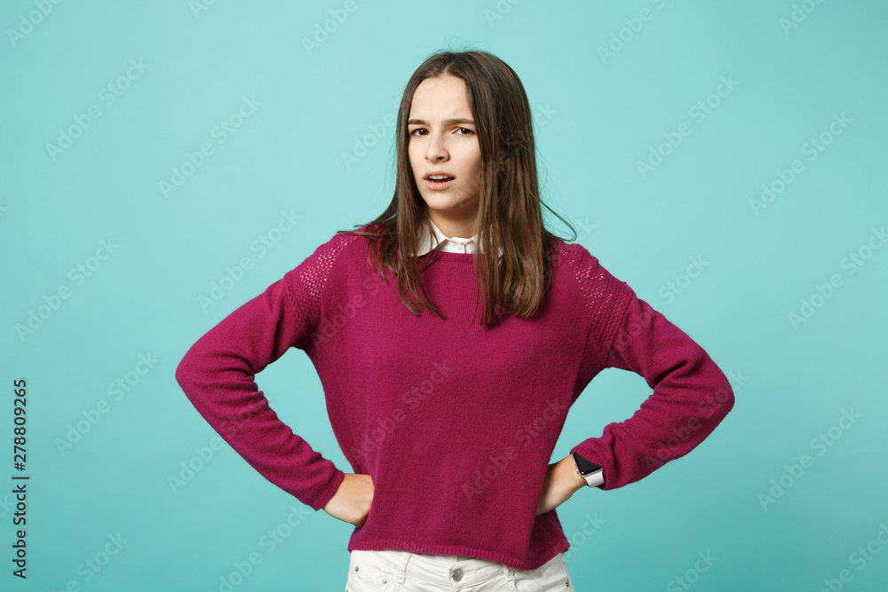 Young fun sad upset perplexed disturb brunette woman girl standing with arms akimbo on waist posing isolated on blue wall background studio portrait. People lifestyle concept. Mock up copy space. Young fun sad upset perplexed disturb brunette woman girl standing with arms akimbo on waist posing isolated on blue wall background studio portrait. People lifestyle concept. Mock up copy space.