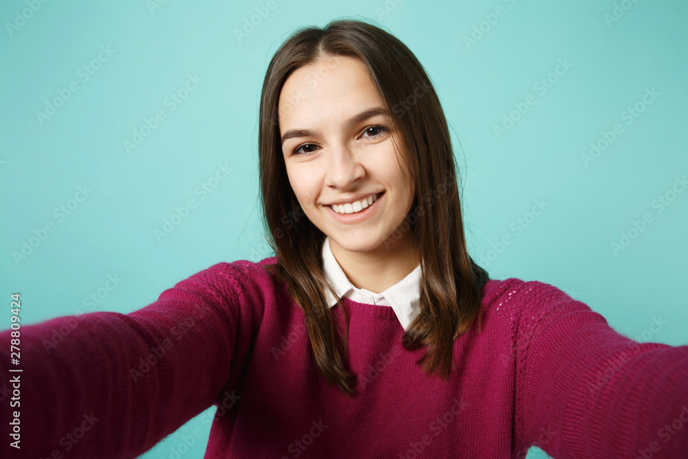 Close up young brunette woman girl in casual clothes posing doing selfie shot on mobile phone isolated on blue background studio portrait. People sincere emotions lifestyle concept. Mock up copy space Close up young brunette woman girl in casual clothes posing doing selfie shot on mobile phone isolated on blue background studio portrait. People sincere emotions lifestyle concept. Mock up copy space