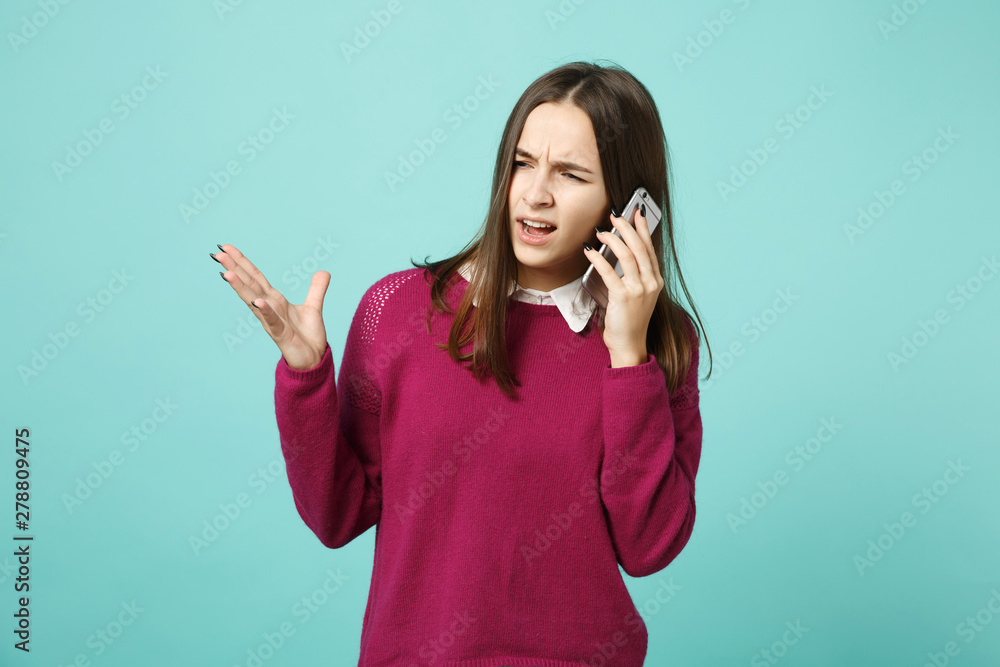 Young brunette woman girl in casual clothes posing isolated on blue green turquoise background studio portrait. People sincere emotions lifestyle concept. Mock up copy space. Talking on mobile phone. Young brunette woman girl in casual clothes posing isolated on blue green turquoise background studio portrait. People sincere emotions lifestyle concept. Mock up copy space. Talking on mobile phone.