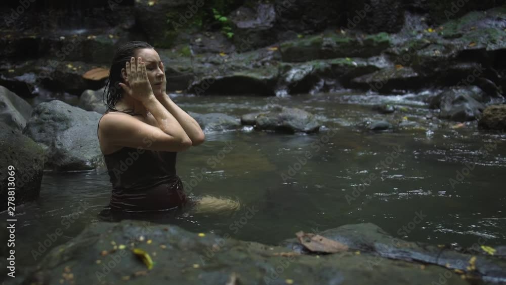 Beautiful pregnant woman in a dark brown dress bathing in the tropical jungle river. Slow motion. Beautiful pregnant woman in a dark brown dress bathing in the tropical jungle river. Slow motion.