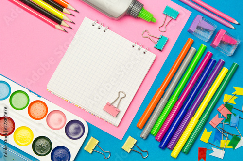 Stationery. School and office supplies on a blue and pink colored background. Selective focus.Advertising space