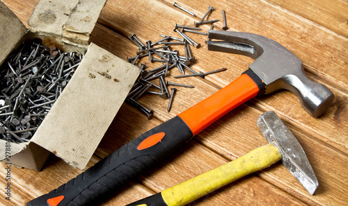 Hammer and nails scattered on wooden background. Joinery concept