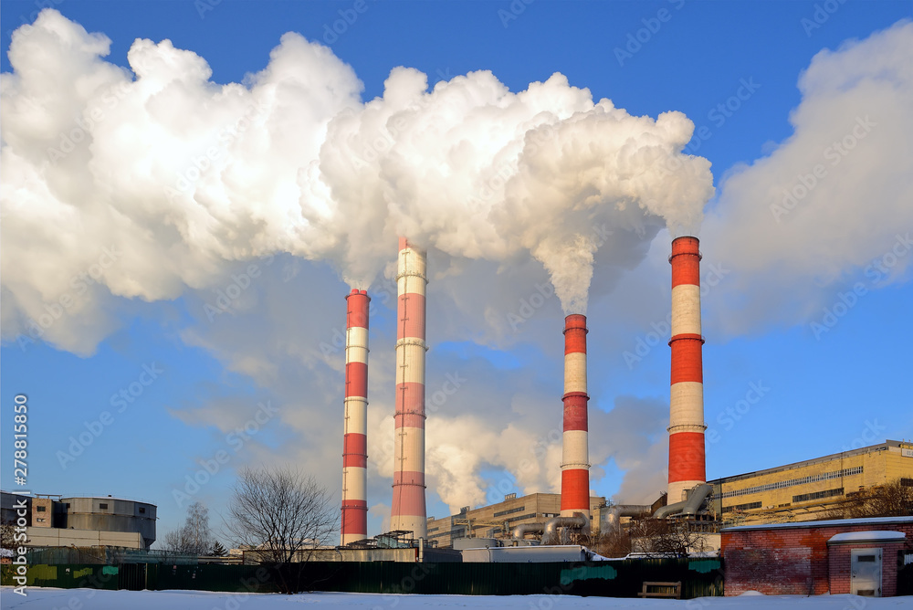 Thermal power plant, smoke from the chimney against blue sky Thermal power plant, smoke from the chimney against blue sky