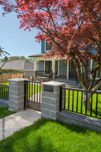 Concrete pathway and metal gate in front of residential house