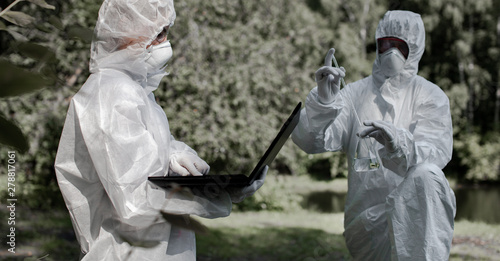 Ecological problem. Pollution. Examine oxygen. Scientist in protective mask and suit taking water samples from river. Chemist makes an analysis of the environment for radiation. Saving planet earth.