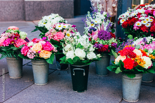 Bright bouquets of flowers are sold in buckets