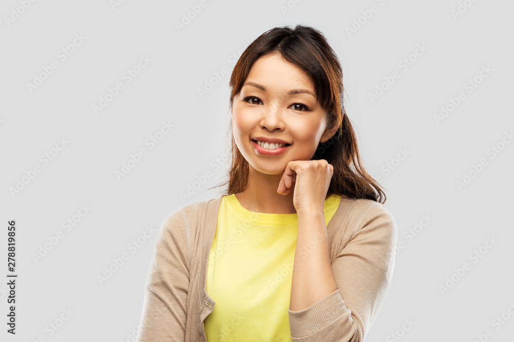 people, ethnicity and portrait concept - happy asian young woman over grey background people, ethnicity and portrait concept - happy asian young woman over grey background