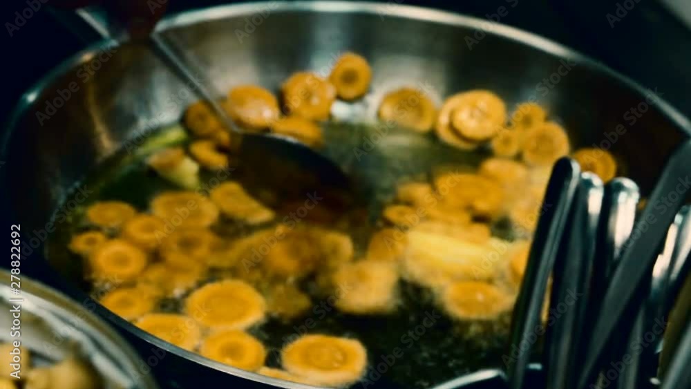 Stirring carrots pieces in pan. Cooking process. Selective focus. Stirring carrots pieces in pan. Cooking process. Selective focus.