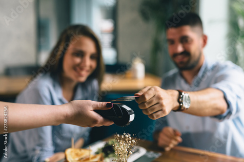 Foto man making payment with smartphone in restaurant