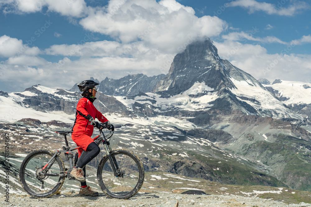 active senior woman, riding her electric mountainbike below the famous Matterhorn in Zermatt, Wallis,Switzerland active senior woman, riding her electric mountainbike below the famous Matterhorn in Zermatt, Wallis,Switzerland