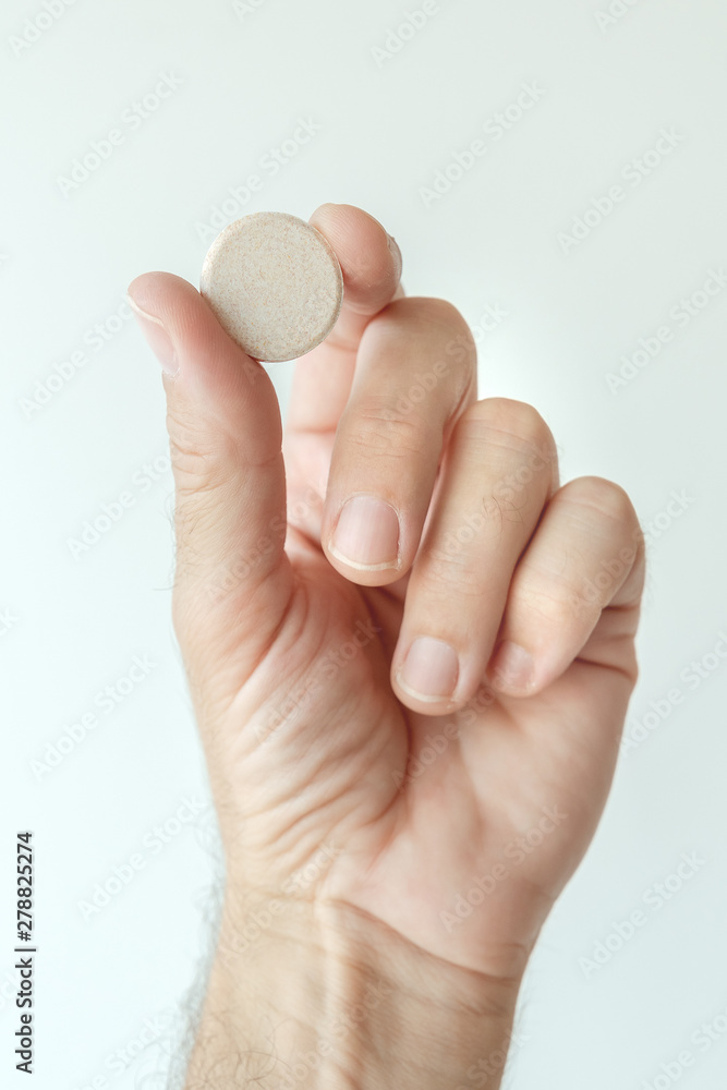 Effervescent vitamin tablet in male hand Effervescent vitamin tablet in male hand