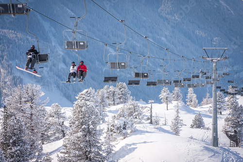Skiers on skilift with frost trees montains. Ski resort in Europe