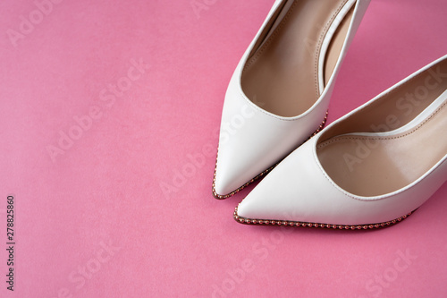 Light white high heels isolated on a bright pink pastel background. Fashion concept