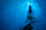 Deep blue ice inside of a glacial ice cave. This tunnel was carved by water melting the ice of the Matanuska Glacier.