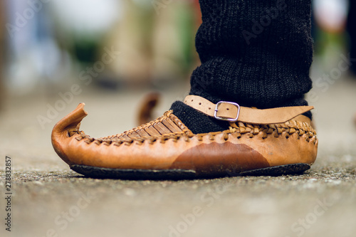 Close up on man feet wearing Serbian National Folk Folklore costume footwear Opanak or opanci on the homemade woolen socks standing outdoor in a day