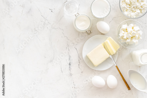 Fresh dairy products for breakfast with milk, cottage, eggs, butter, yougurt on white marble background top view mock up