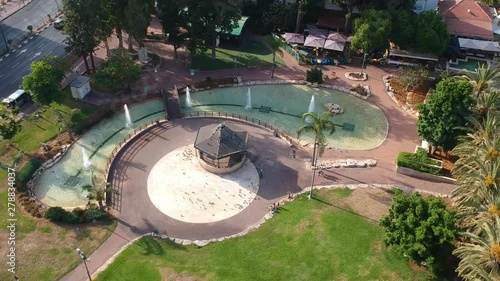 A drone flies over a beautiful gazebo in the park on the background of fountains