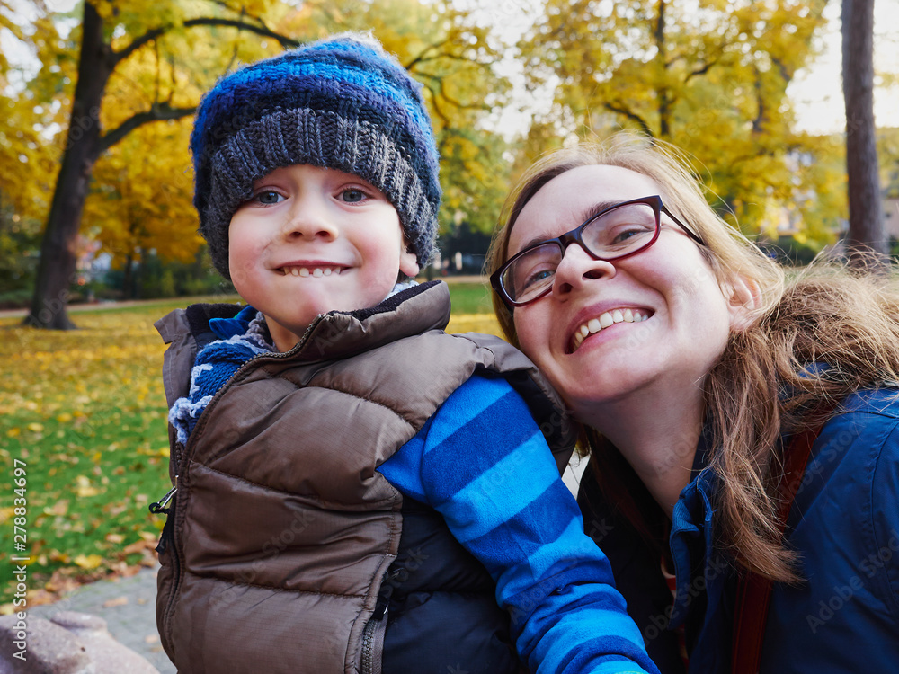 Portrait of mother and little son in an autumnal park