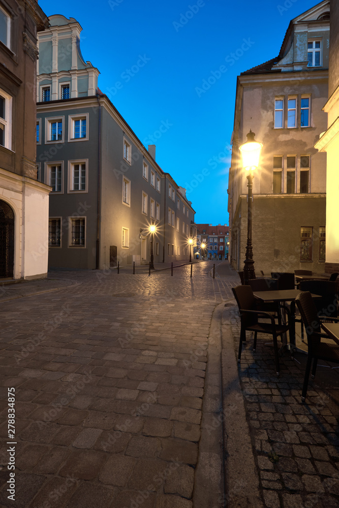 Narrow street illuminated with street lights leading to the Market Square in Poznan, Poland