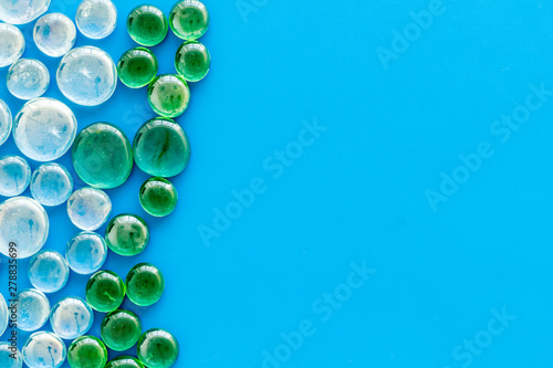 Pattern from colored glass stones on blue background top view mockup