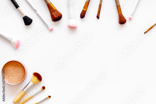 Brushes for make up, powder on white visagiste work desk background top view copyspace