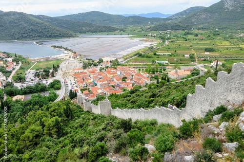 A view high up from the walls of Ston overlooking the town of Ston, Croatia. The wall is an ancient defensive wall made of limestone. The wall is known as the European Wall of China