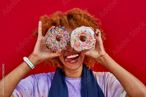 Playful woman holding two donuts in front of her eyes photo