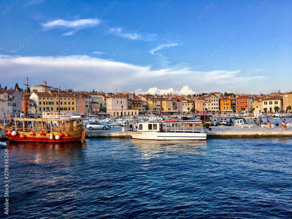 A view of the waterfront of Rovinj, Croatia full of colourful old buildings and boats docked in the bay.  A beautiful old croatian town along the Istria peninsula.