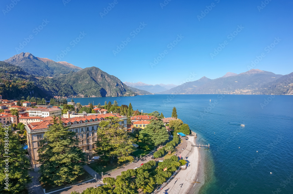 Aerial view landscape on beatiful Lake Como in Menaggio, Lombardy, Italy. Scenic small town with traditional houses and clear blue water. Summer vacation for tourists on rich resort with nice harbour