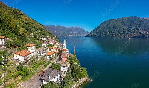 Aerial view landscape on beatiful Lake Como in Lombardy, Italy. Scenic small town with traditional houses and clear blue water. Summer tourist vacation on rich resort with nice harbour