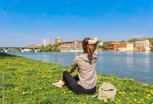 Tourist woman in French ancient town Toulouse and Garonne river. Toulouse is the capital of Haute Garonne department and Occitanie region, France, South Europe. Famous city and tourist destionation.