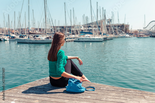 Tourist woman in the port of Barcelona, Catalonia, Spain. Scenic seascape of marina and sailboats yachts. Public promenade and famous tourist destination near La Ramblaa street © oleg_p_100
