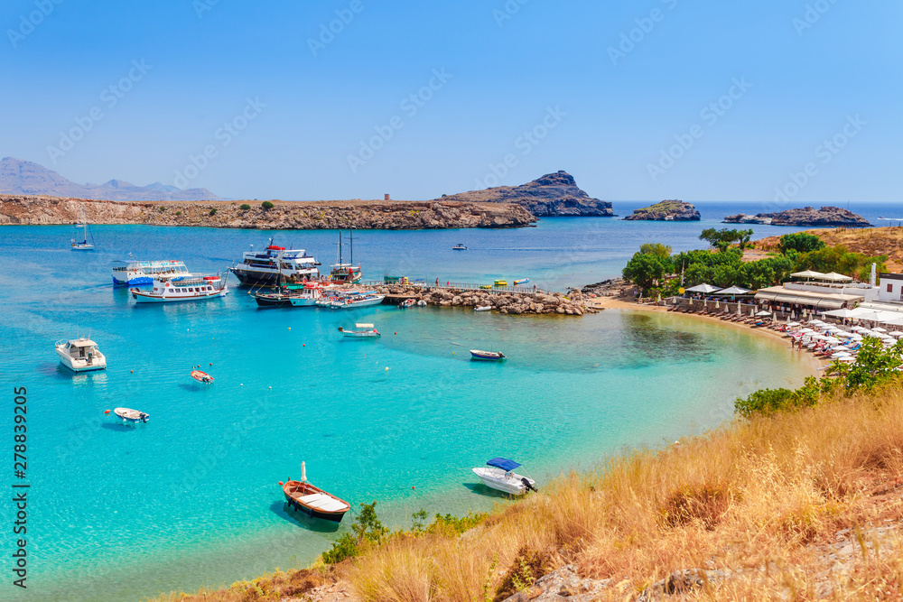 Sea skyview landscape photo Lindos bay and sea coast on Rhodes island, Dodecanese, Greece. Panorama with nice sand beach and clear blue water. Famous tourist destination in South Europe