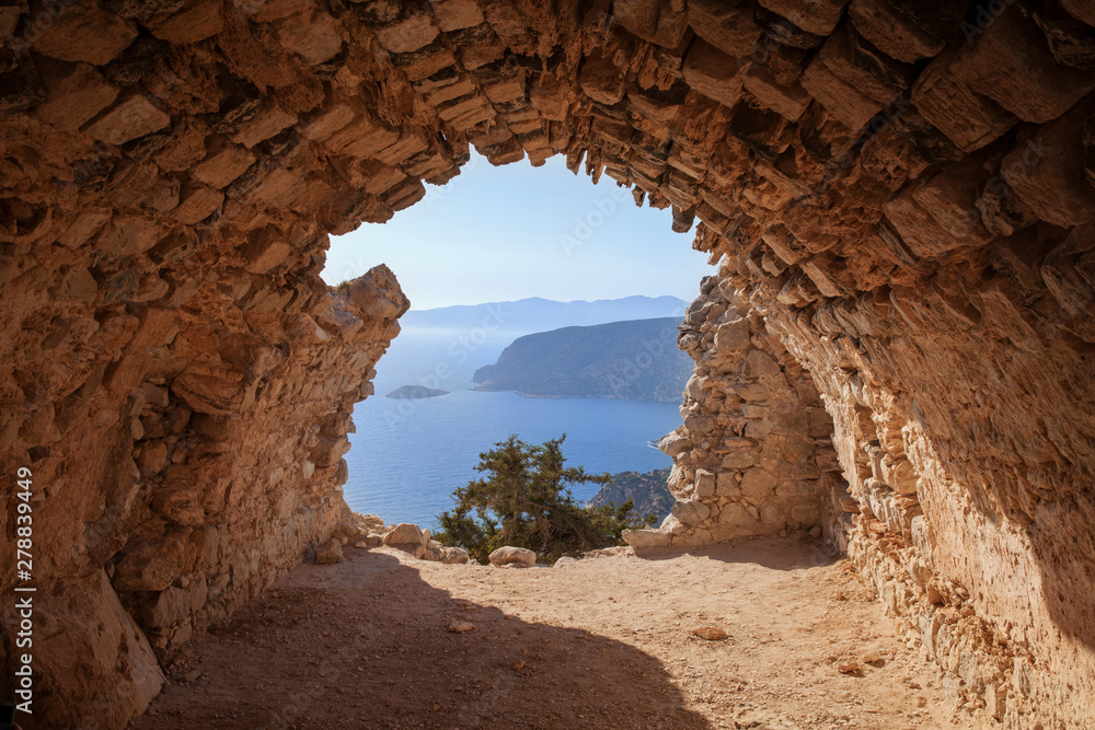 Sea skyview landscape photo from ruins of Monolithos castle on Rhodes island, Dodecanese, Greece. Panorama with green mountains and clear blue water. Famous tourist destination in South Europe