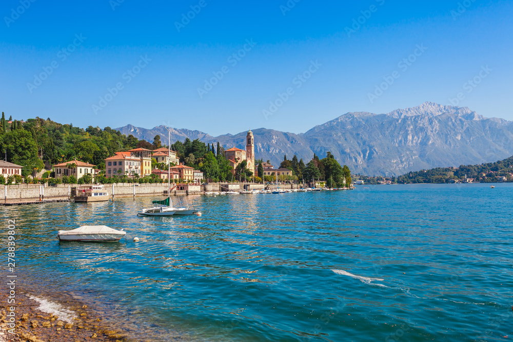 Panorama landscape on beatiful Lake Como in Tremezzina, Lombardy, Italy. Scenic small town with traditional houses and clear blue water. Summer tourist vacation on rich resort with nice harbour