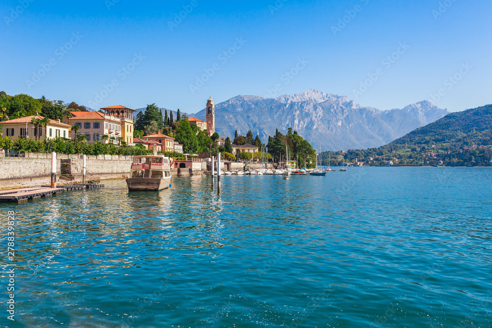 Panorama landscape on beatiful Lake Como in Tremezzina, Lombardy, Italy. Scenic small town with traditional houses and clear blue water. Summer tourist vacation on rich resort with nice harbour