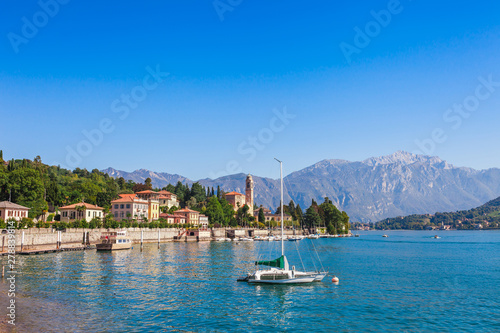Panorama landscape on beatiful Lake Como in Tremezzina, Lombardy, Italy. Scenic small town with traditional houses and clear blue water. Summer tourist vacation on rich resort with nice harbour © oleg_p_100