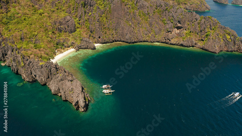 Aerial drone tropical landscape bay with beach and clear blue water surrounded by cliffs. El nido, Philippines, Palawan. Seascape with tropical rocky islands, ocean blue water. Summer and travel