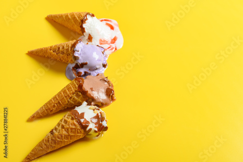 multiple flavor ice cream cones in a melting process on yellow background with copy space