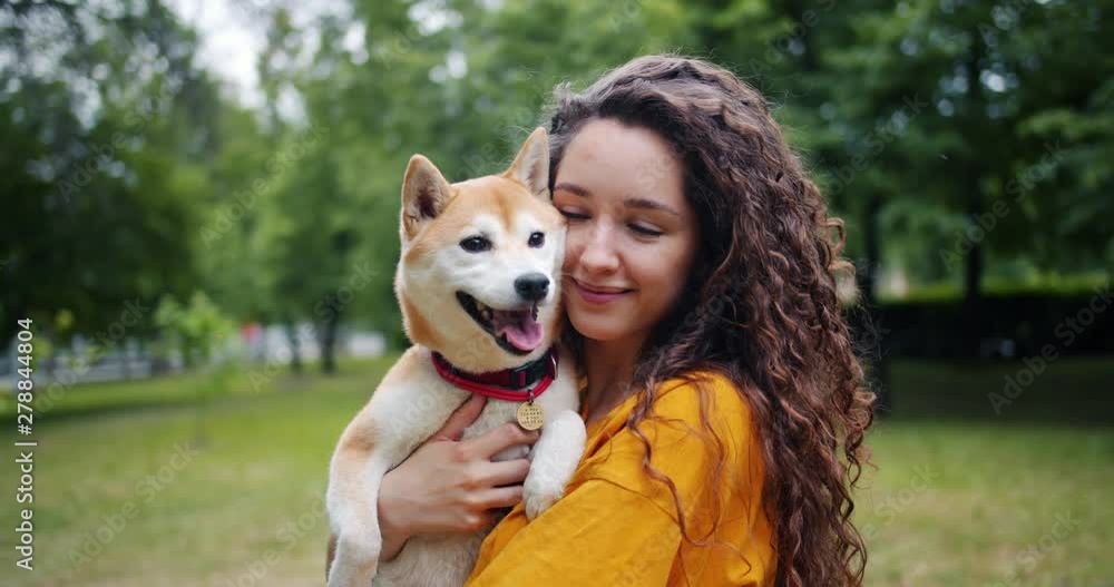 Portrait of pretty girl loving dog owner standing in park with her beautiful pet, smiling and looking at camera. Adorable animals and summer nature concept. Portrait of pretty girl loving dog owner standing in park with her beautiful pet, smiling and looking at camera. Adorable animals and summer nature concept.