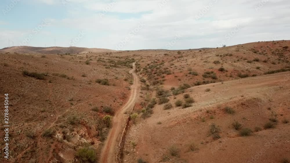 Aerial: Drone shot following a dusty track in the outback just outside of Broken Hill, Australia Aerial: Drone shot following a dusty track in the outback just outside of Broken Hill, Australia