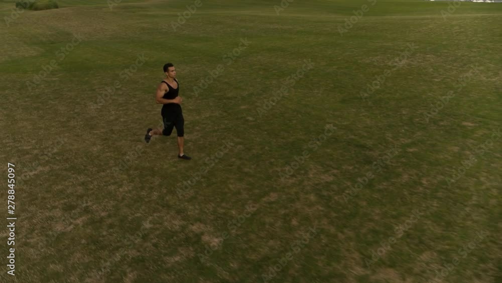 Man running on green meadow Follow camera flyby shot video. Sportsman Runner Athlete training Man running on green meadow Follow camera flyby shot video. Sportsman Runner Athlete training