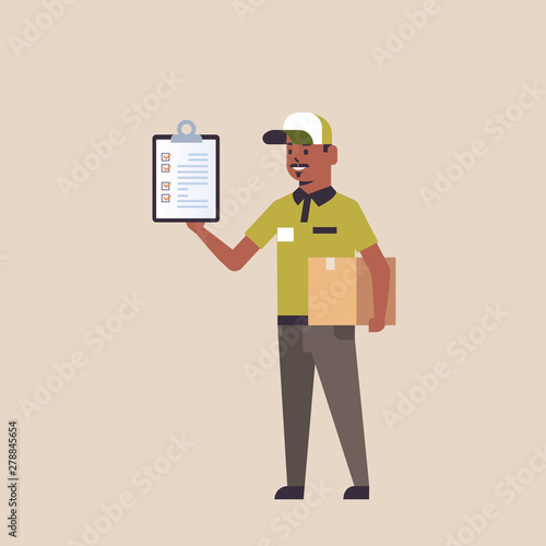 postman in uniform holding cardboard parcel box and receiving form clipboard african american courier express delivery service concept flat full length