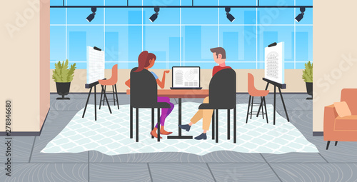 architects couple using laptop engineers drafting house project on computer screen with blueprints housing contractors designing house plan modern draftsman studio interior full length