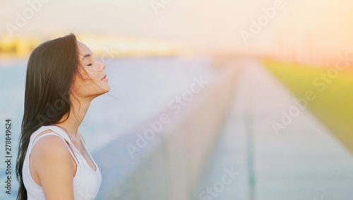 Side view profile portrait of a happy brunette woman relaxing breathing fresh air outdoors in summer Girl close eyes doing deep breath exercises. Positive emotion success, peace of mind, zen concept.