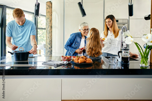 Three generation family preparing food in kitchen photo